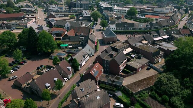 Aerial footage of Budel centre in Cranendonck village, showcasing charming streets, historical buildings, and lush greenery. Captured on a sunny day, highlighting the picturesque scenery.
