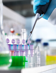 Cropped hand of scientist pipetting DNA samples into vials for experiment in laboratory