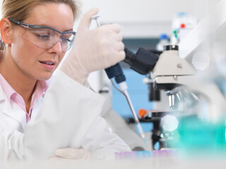 DNA Research, Scientist pipetting a DNA sample into a tube ready for automated analysis in the...