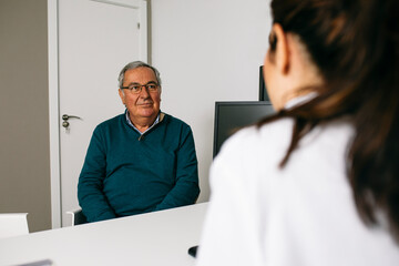 Fototapeta premium Patient looking at doctor during a consultation in medical practice