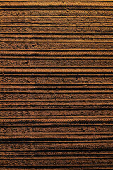 Fototapeta premium Aerial shot of tractor tread marks forming forming pattern in plowed field soil, drone pov