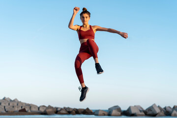 Sportive young woman during workout, jumping