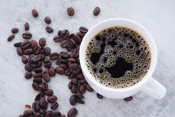 淹れたてで香りのよいコーヒーが入ったカップと、コーヒー豆
