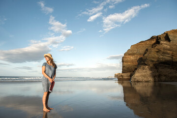 Woman standing on beach, looking at sea