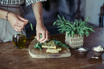 Young woman garnishing homemade chickpea and herb cake