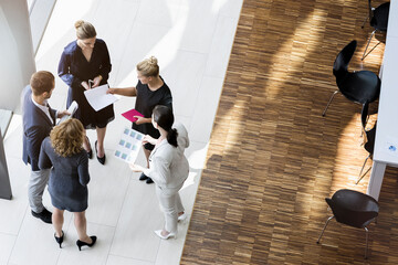Business people standing in modern office building discussing project
