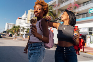 USA, Florida, Miami Beach, two happy female friends with ice cream cones in the city