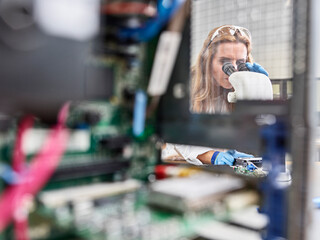 Female technician working with microscope in research laboratory
