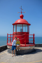 Family with children, visiting the beach with the biggest waves in the world in Nazare, Portugal