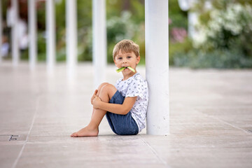 Beautiful portrait of young barefeet child, walking in Monaco, beautiful white terrace next to the...