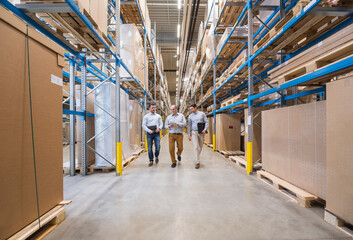 Three men walking in factory warehouse