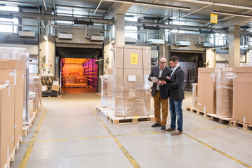 Two men talking in factory warehouse