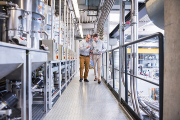 Two men in factory shop floor talking about product