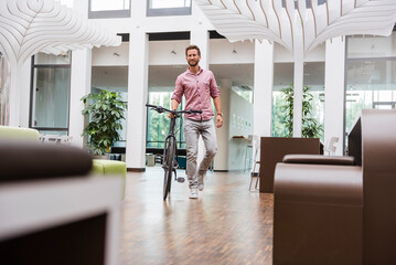 Man with bicycle walking in office