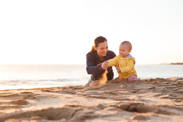 Mother playing with little daughter on the beach