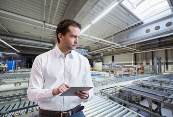 Businessman using tablet on factory shop floor