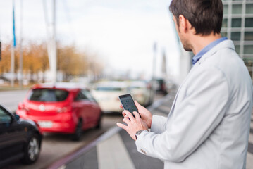Businessman looking for a car with his car sharing app