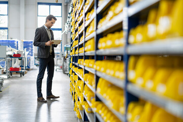 Businessman using tablet in storehouse of a factory