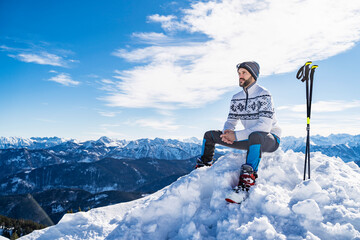 Germany, Bavaria, Brauneck, man in winter sitting on mountaintop