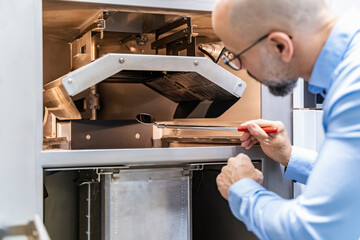 Man holding mirror examimning 3d printer