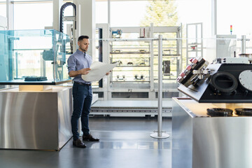 Businessman looking at plan in modern factory