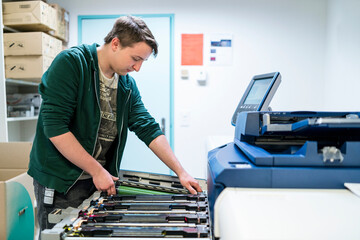 Teenager working at color printer
