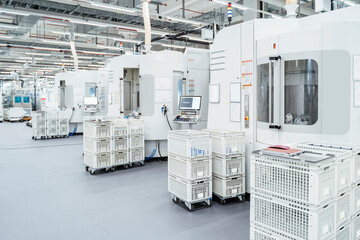Crates stacked in front of industrial machinery inside modern factory, Stuttgart, Germany