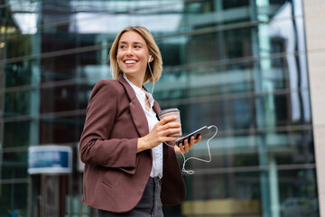 Happy young businesswoman in the city on the go