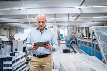 Businessman using tablet in a factory