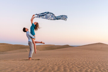 Carefree couple at sunset in the dunes, Gran Canaria, Spain