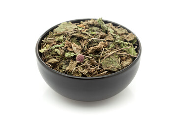 Close-up of Dry Organic Gymnema or Gurmar (Gymnema sylvestre) leaves, in black ceramic bowl. Isolated on a white background.