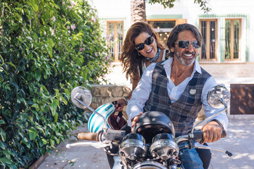 Portait of happy mature couple on a vintage motorbike