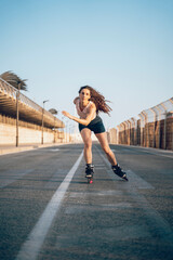 Young woman inline skating on boardwalk at the coast