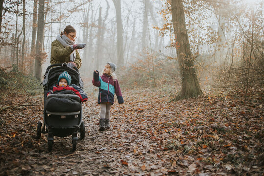 Mother with daughters during forest walk in autumn