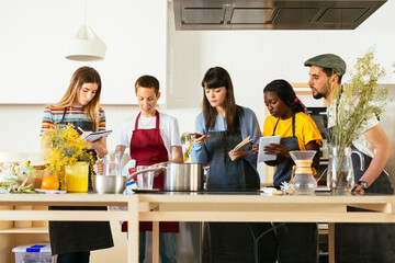 Friends in a cooking workshop listening to instructor