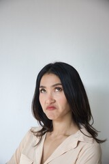 Fototapeta premium Displeased, not pleasing, upset, unhappy young adult Asian woman rolling her eye with stress and failure, smart casual office worker outfit