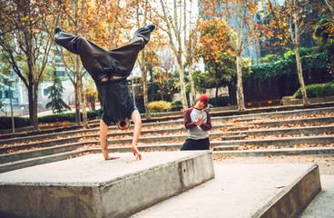 Young man performing handstand by friend in park