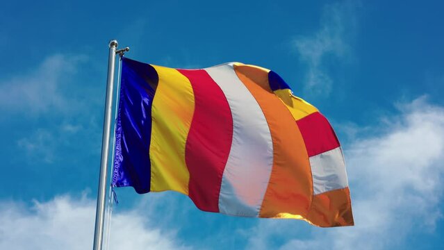 Buddhist flag waving in front of blue sky in Phnom Penh, Cambodia