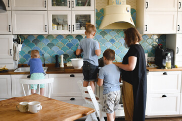 Mother cooking with her three sons in the kitchen