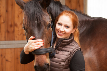 Portrait of happy young woman with her horse