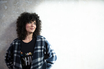 Portrait of smiling woman leaning against concrete wall