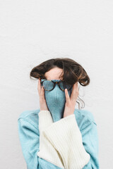 Young woman covering her face with turtle neck