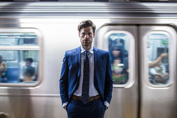 Businessman standing in front of leaving metro train