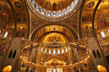 Obraz premium The interior of the Church of Saint, St. Sava, a big golden Chandelier in front of golden walls, vaults, ceiling covered in mosaics, Belgrade, Serbia