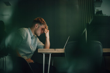 Tired man sitting in office, working late in his start-up company