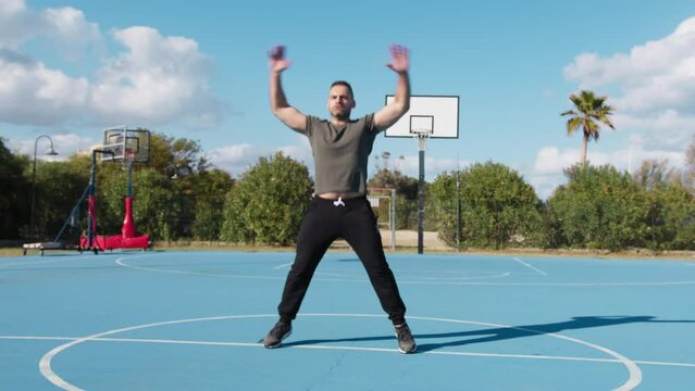 Man Trains With Jumping Jack Outside In Basketball Court