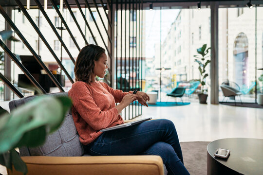 Young woman checking the time in a foyer