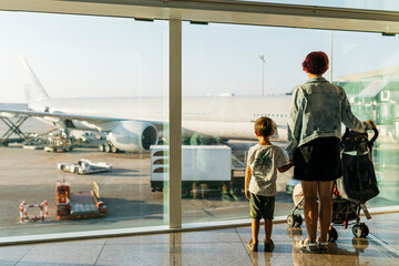 Spain, Barcelona airport, Mother and son waiting in departure area