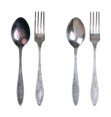 Sterling silver spoon and fork, tarnished and cleaned, isolated from above. On the left side spoon and fork with dark layers of corrosion, and on the right side same ones after cleaning and polishing.
