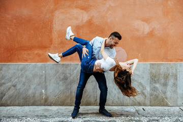 Carefree couple in love in front of a wall outdoors